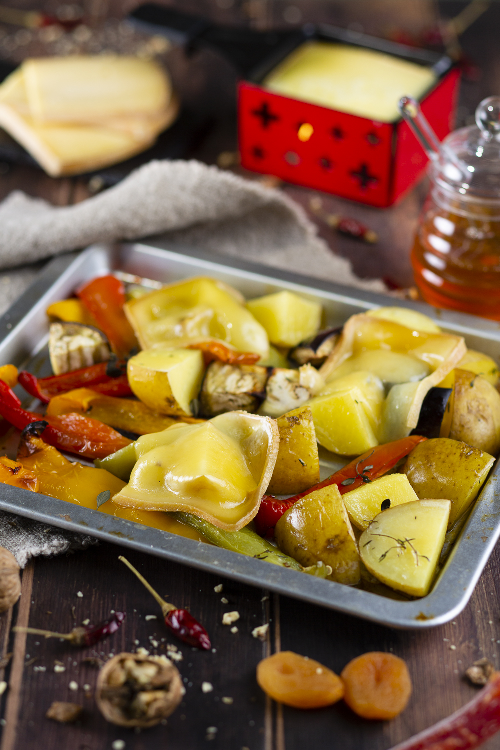 Raclette Suisse® su mezze patate abbrustolite, melanzane, peperoni e affettati misti