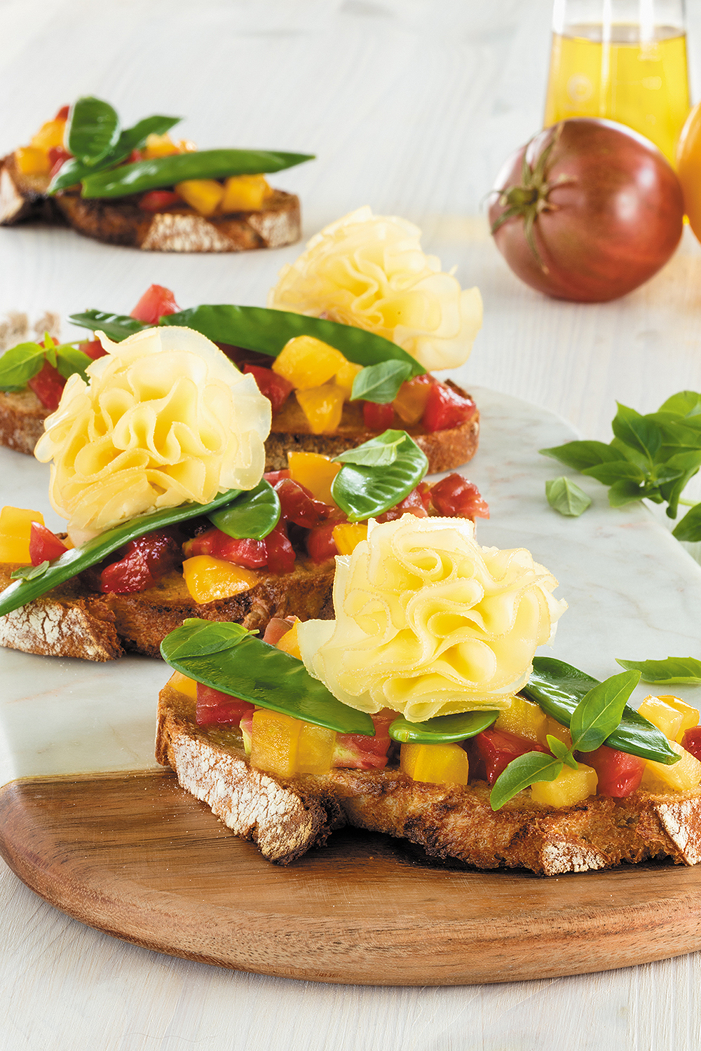 Bruschette con basilico, pomodorini e rosette di  Tête de Moine DOP